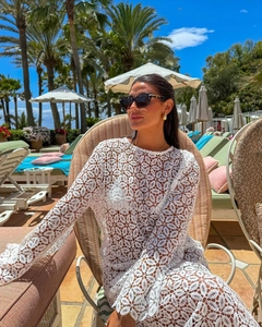 Detailed view of white crochet lace long sleeve dress featuring intricate floral patterns