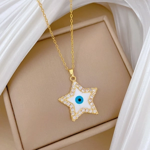 Gold star necklace with blue evil eye enamel and cubic zirconia on silk fabric