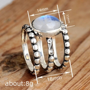 Bague vintage triple anneau en argent avec pierre de lune sur fond de bois