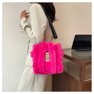 Detail view of pink plush tote bag with black strap and Have a Nice Day text embroidery