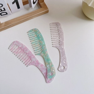 Three marble acetate wide-tooth combs in pink, mint, and purple with hanging holes