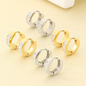 Macro detail of gold and silver huggie earrings with cubic zirconia pave settings