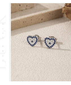 Detailed macro view of S925 sterling silver heart-shaped evil eye stud earrings