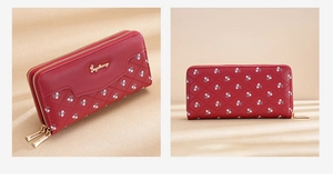 Detail of red long wallet with quilted floral patterns and dual gold zipper closure