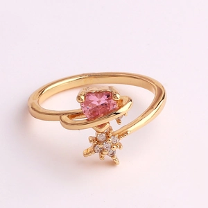 Detail of gold-plated ring with a heart-shaped pink zircon and orbital star design