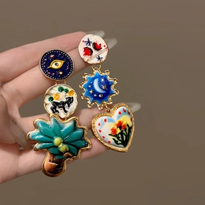 Artistic asymmetric enamel drop earrings with eye and celestial motifs in gold finish