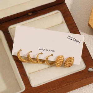 Gold stainless steel twisted hoop and oval stud earrings set on a display card