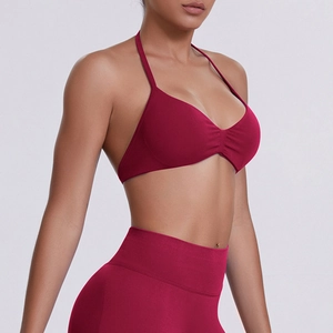 Detail of seamless halter neck sports bra with ruched chest and high-stretch fabric in dark red