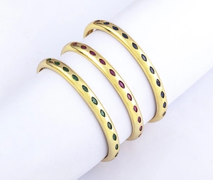 Detailed view of three 18k gold plated C-shape bangles with colorful zircon inlay