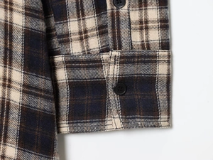 Detailed macro view of retro plaid flannel shirt cuff with button and neat stitching