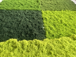 Detailed view of artificial moss panels in deep green, emerald, and yellow shades