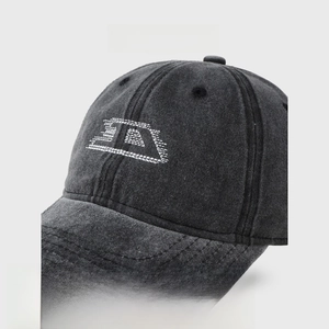 Detail of dark grey washed denim baseball cap with 3D white embroidered letter logo
