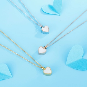 Three-color heart pendant necklaces in gold, silver and rose gold on light blue backdrop
