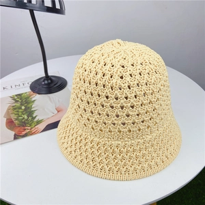 Detail of hollow knit crochet pattern on beige sun hat showing breathable mesh texture