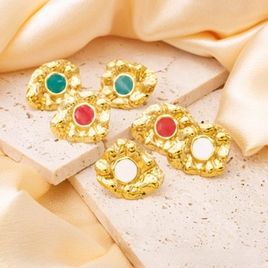 Detailed macro view of vintage gold-plated earrings with colorful enamel and hammered texture