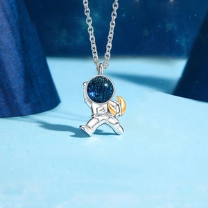 Detailed close-up of astronaut pendant with golden moon and starry blue helmet detail