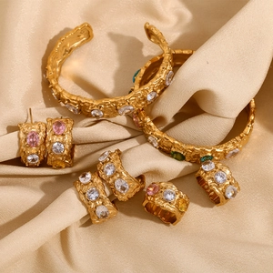 Vintage 18K gold plated jewelry set with colorful zircons on silk background