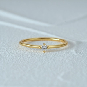 Macro shot of a minimalist gold S925 silver ring featuring a four-prong set cubic zirconia