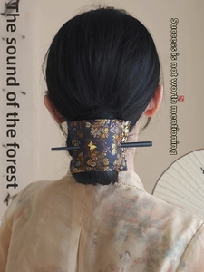 Detail of embroidered brocade flower hair wrap with gold butterfly and black hairpin