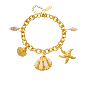 Gold stainless steel ocean bracelet with starfish, scallop and conch charms on white background
