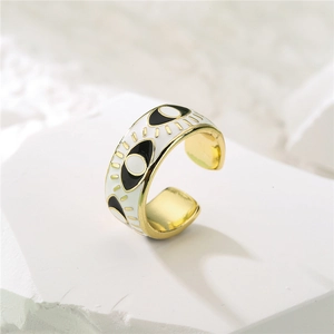 Macro detail of 18K gold plated evil eye ring with black and white enamel finish