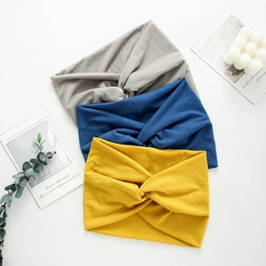 Close-up of three yoga headbands in gray, blue and yellow with a stylish center twist