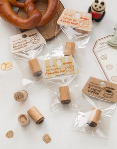 Close-up of bakery-themed wooden stamps with toast and pretzel patterns for DIY journals