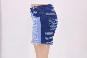 Detail view of high-waist denim shorts featuring side distressed holes and contrast patchwork