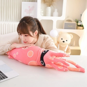 Pink plush squid toy with orange spots used as a cozy home pillow in a warm bedroom setting