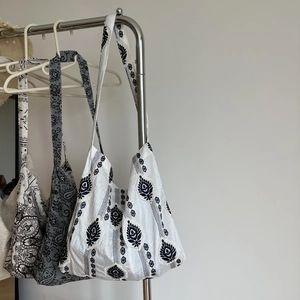 Detailed view of linen tote bags with ethnic embroidery and paisley floral patterns
