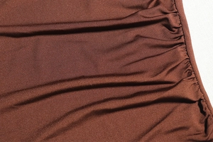Close-up of brown ruched fabric detailing showing silky texture and pleated design