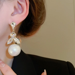 Detail of silver needle pearl tassel earrings with rhinestones on a female model