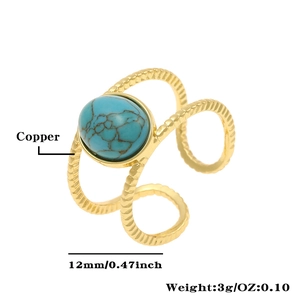 Macro detail of gold plated copper ring with oval turquoise stone and spiral band