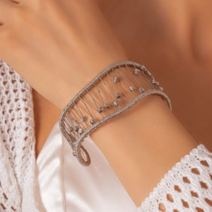 Détail d'un bracelet manchette en fil d'argent torsadé avec perles sur textile tissé