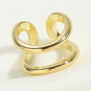 Macro shot of minimalist gold double helix open ring with smooth metallic texture