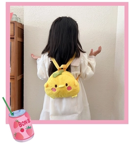 Detail view of a plush yellow chick backpack with green leaf worn by a child