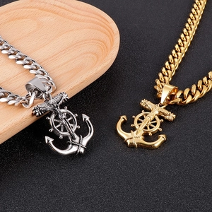 Détail de pendentifs ancre croix en or et argent sur chaînes cubaines pour homme