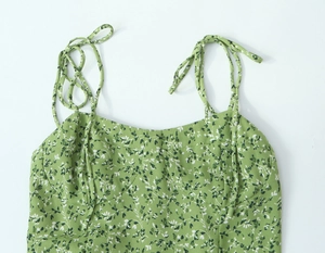 Gros plan détaillé des bretelles à nouer d'une robe d'été fleurie verte légère