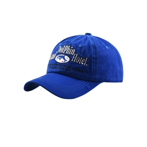 Close-up of Dolphin Hotel white embroidery on bright blue cotton twill baseball cap
