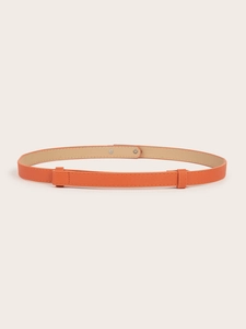 Close-up of slim orange waist belt with Saffiano texture and metal rivet detail