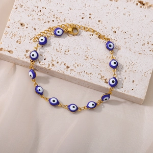 Detailed macro view of the gold Evil Eye chain bracelet with blue enamel beads and lobster clasp