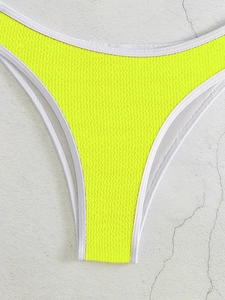 Nahaufnahme der neongelben Bikinihose mit Waffelstruktur und weißen Kontrastnähten