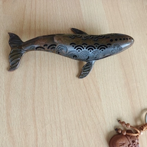 Macro detail of whale-shaped bronze incense burner with hollowed wave patterns