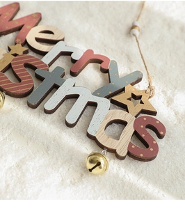 Close-up of wooden Merry Christmas hanging signs with gold bells and hemp rope on snow