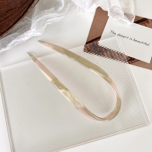 Detail view of U-shaped hair pin with amber and pink gradient acetate finish