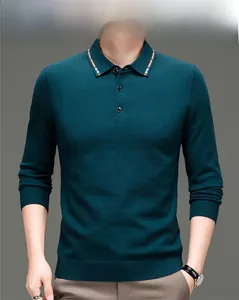 Detail eines dunkelgrünen Strickpolos mit gestreiftem Kragen und Rippbündchen