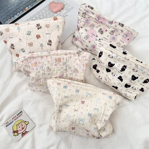 Close-up of quilted cotton cosmetic bags with cartoon bear and floral patterns