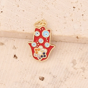 Macro detail of red enamel Hamsa hand pendant with blue evil eye and floral gemstone inlay