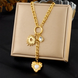Dettaglio della collana a Y dorata con ciondoli a sole, goccia e cuore di perla