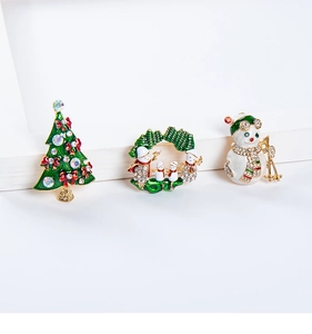 Macro view of Christmas tree and snowman brooches with colorful rhinestones and enamel